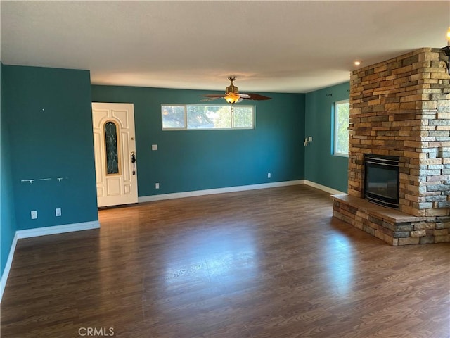 unfurnished living room featuring a fireplace, ceiling fan, and dark hardwood / wood-style flooring