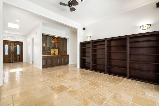 interior space featuring ceiling fan, crown molding, and a skylight