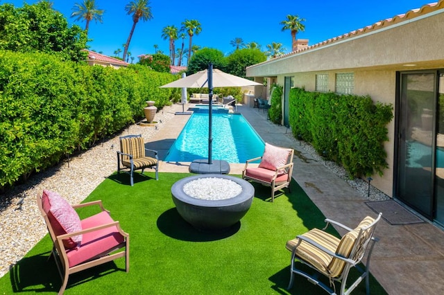 view of pool featuring a yard, a patio, and an outdoor fire pit