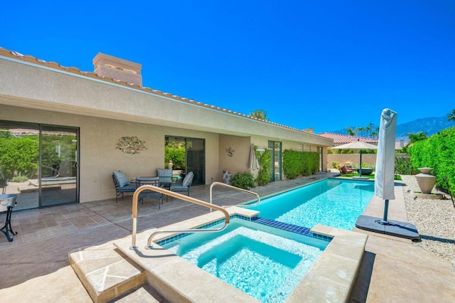 view of pool with an in ground hot tub and a patio area