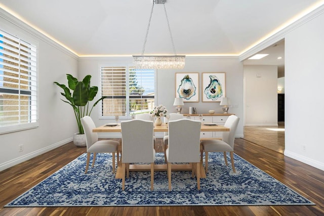 dining room with dark hardwood / wood-style floors, a healthy amount of sunlight, crown molding, and a chandelier