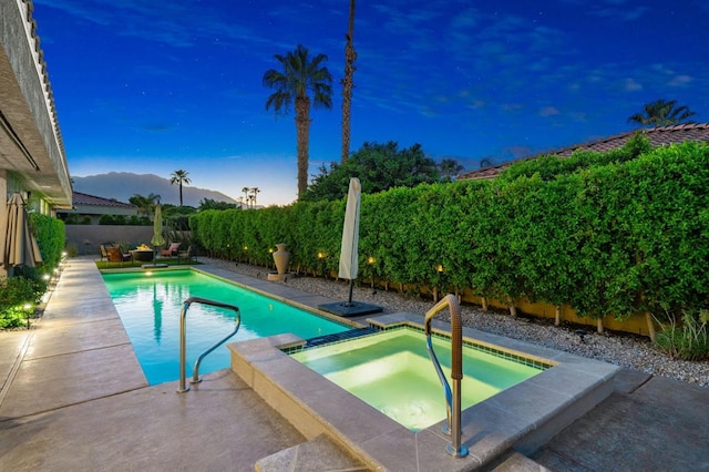 view of swimming pool featuring a mountain view and an in ground hot tub