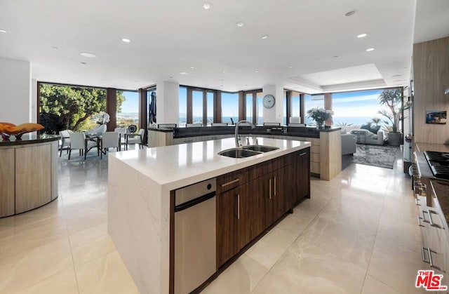 kitchen featuring dark brown cabinets, a wealth of natural light, a spacious island, and sink