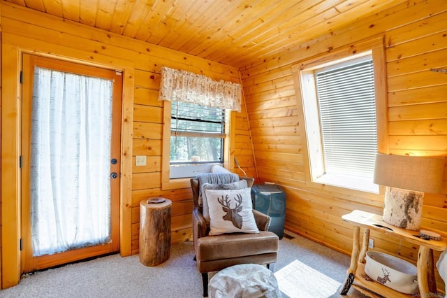 living area featuring wood ceiling, wood walls, and light colored carpet