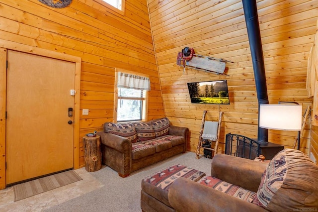 carpeted living room featuring wooden walls and a wood stove