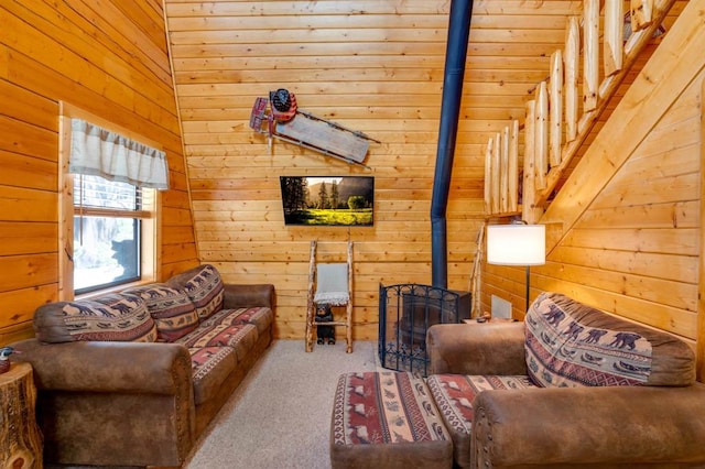 carpeted living room with wood walls and a wood stove