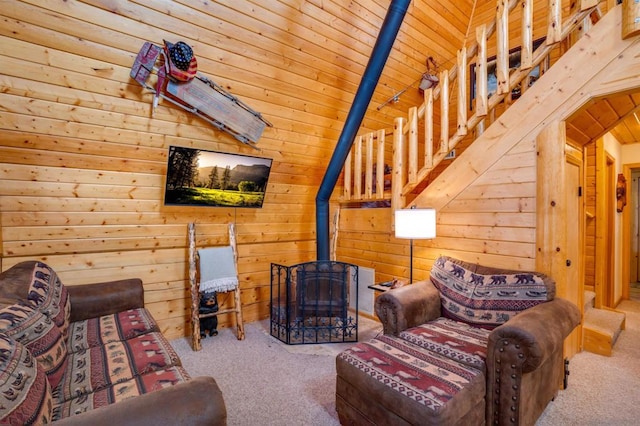 living room with carpet flooring, wood walls, and vaulted ceiling