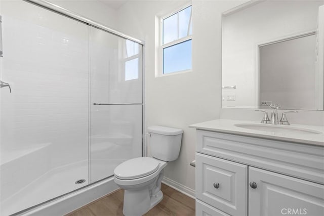 bathroom featuring hardwood / wood-style floors, vanity, toilet, and a shower with door