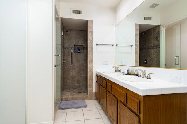 bathroom featuring tile patterned flooring, vanity, and a shower with shower door