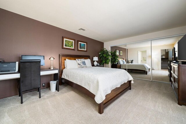 bedroom featuring a closet and light colored carpet