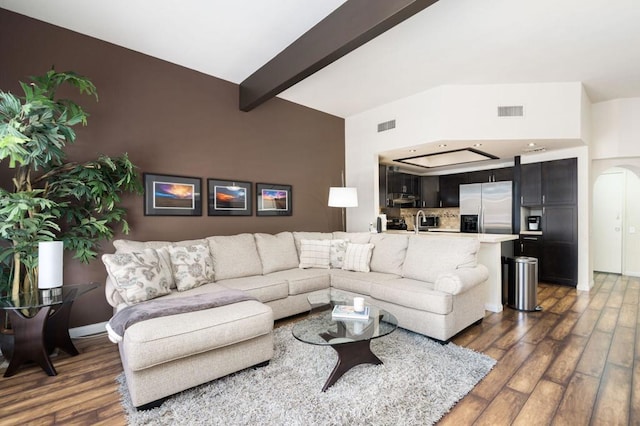 living room with beamed ceiling, dark hardwood / wood-style flooring, sink, and a high ceiling