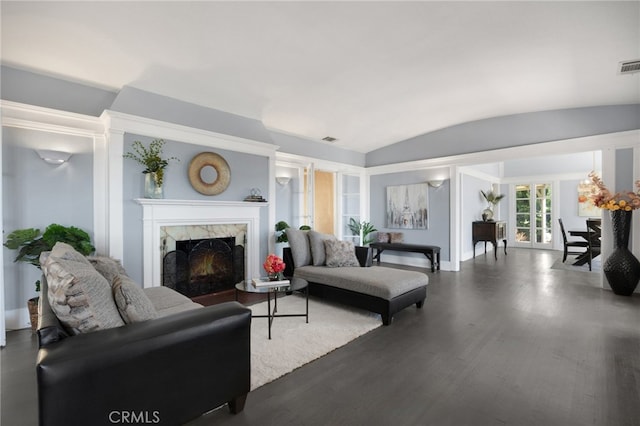 living room with wood-type flooring, lofted ceiling, and a high end fireplace