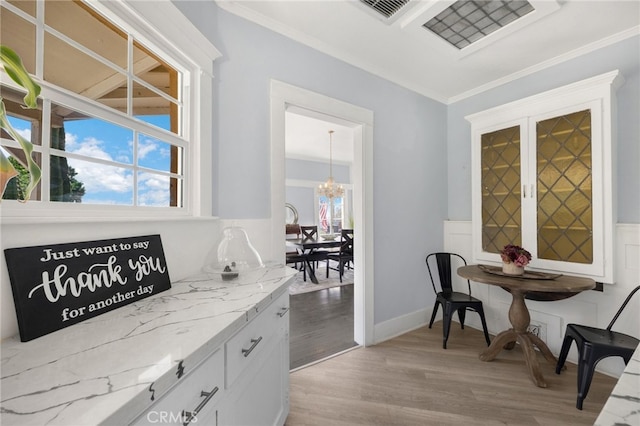 home office with crown molding, an inviting chandelier, and light hardwood / wood-style flooring