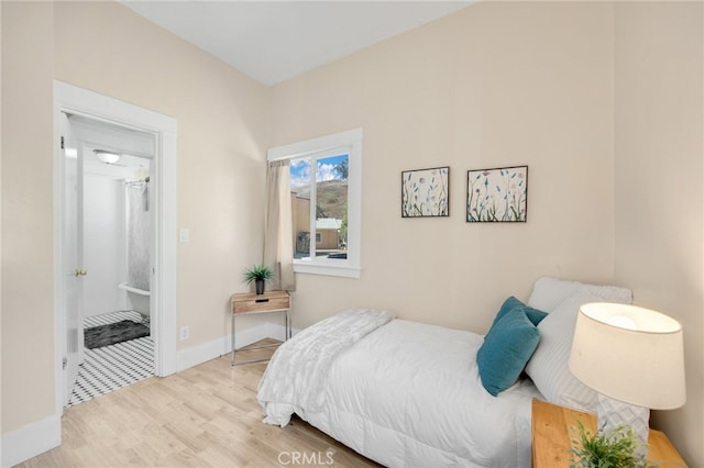 bedroom with light hardwood / wood-style flooring and ensuite bath