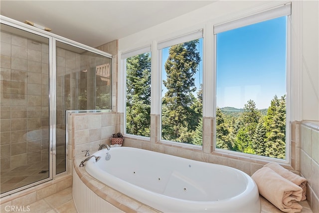 bathroom featuring plus walk in shower, tile patterned flooring, and a wealth of natural light