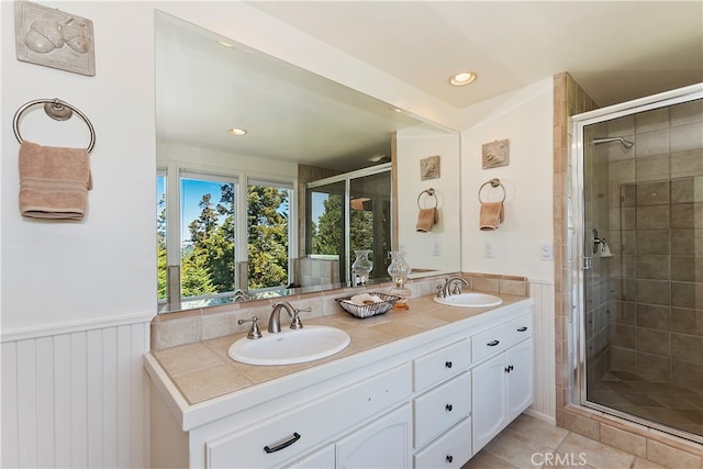 bathroom with vanity, a shower with shower door, and tile patterned floors