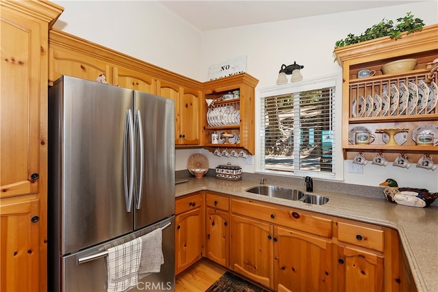 kitchen with stainless steel refrigerator, light hardwood / wood-style floors, and sink