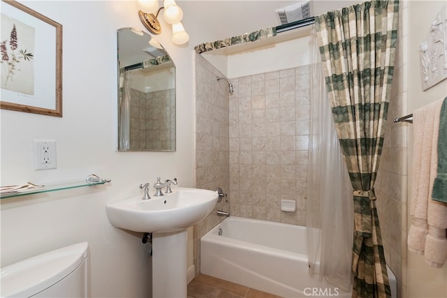 bathroom featuring shower / tub combo, toilet, and tile patterned floors