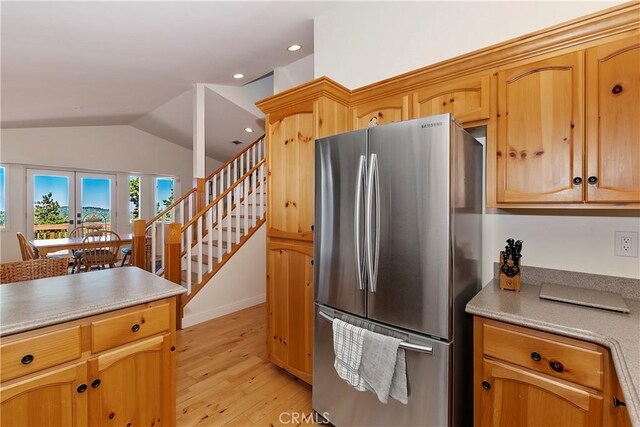 kitchen with stainless steel refrigerator, light hardwood / wood-style flooring, and vaulted ceiling