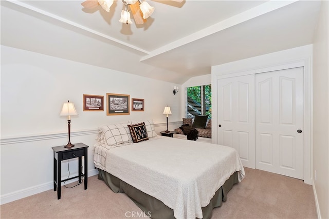 bedroom with vaulted ceiling, light carpet, ceiling fan, and a closet