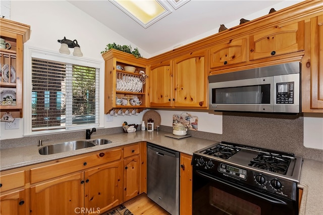 kitchen with sink, backsplash, stainless steel appliances, light wood-type flooring, and vaulted ceiling