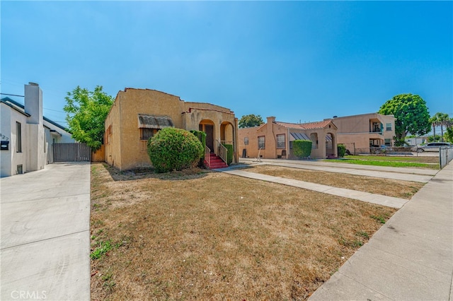 pueblo revival-style home with a front lawn