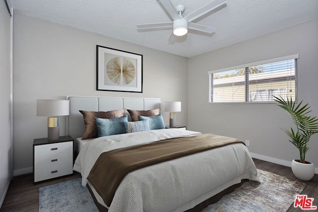 bedroom with a textured ceiling, dark hardwood / wood-style flooring, and ceiling fan