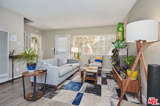 living room featuring a textured ceiling and hardwood / wood-style floors