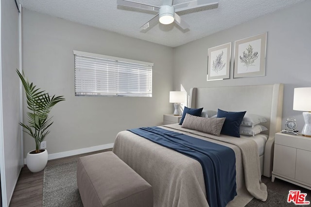 bedroom with a textured ceiling, dark hardwood / wood-style flooring, and ceiling fan