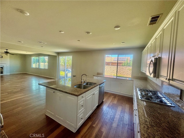 kitchen with ceiling fan, white cabinets, sink, a kitchen island with sink, and stainless steel appliances