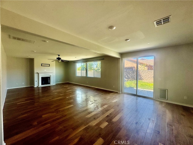 unfurnished living room with ceiling fan and dark wood-type flooring