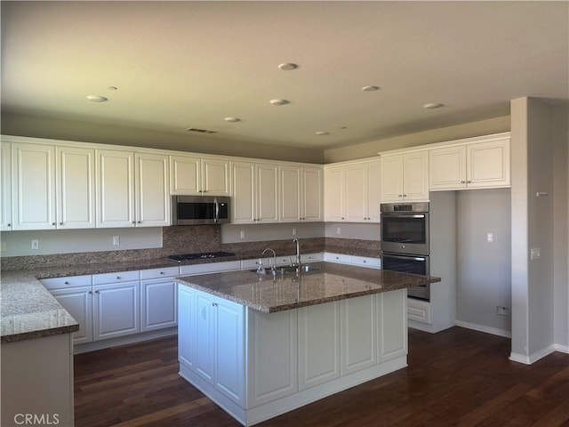 kitchen featuring a center island with sink, appliances with stainless steel finishes, sink, and white cabinetry