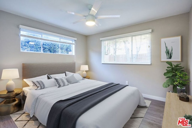 bedroom featuring wood-type flooring, multiple windows, and ceiling fan