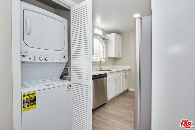 clothes washing area featuring stacked washer and clothes dryer, light hardwood / wood-style floors, and sink