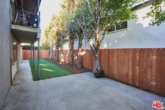 view of yard with a balcony and a patio area