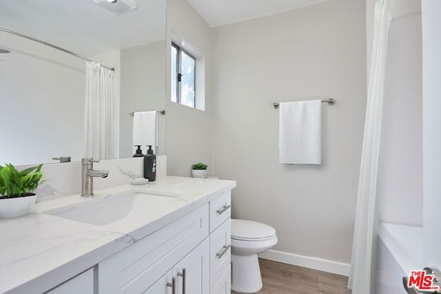 bathroom with a shower with curtain, vanity, toilet, and hardwood / wood-style flooring