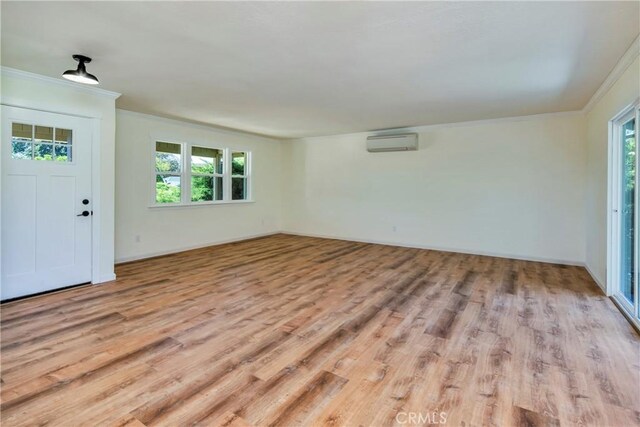 entrance foyer featuring light hardwood / wood-style floors, an AC wall unit, and a wealth of natural light