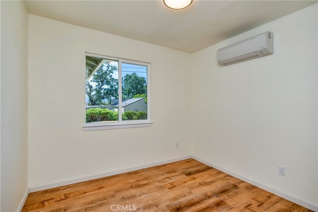 empty room with a wall unit AC and hardwood / wood-style flooring