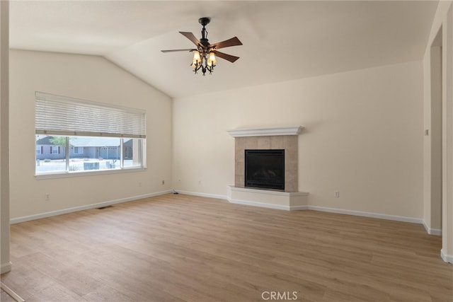 unfurnished living room featuring wood-type flooring, vaulted ceiling, ceiling fan, and a fireplace