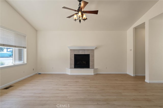 unfurnished living room featuring ceiling fan, light hardwood / wood-style flooring, lofted ceiling, and a tile fireplace