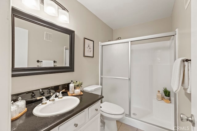 bathroom featuring tile patterned flooring, vanity, toilet, and a shower with shower door