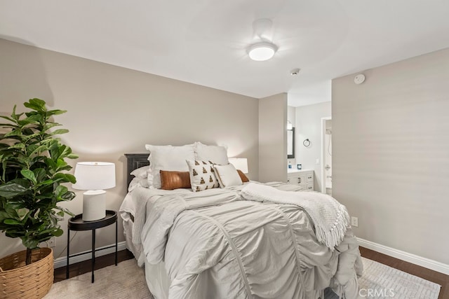 bedroom with wood-type flooring and ensuite bathroom