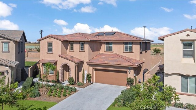 mediterranean / spanish-style home with solar panels and a garage