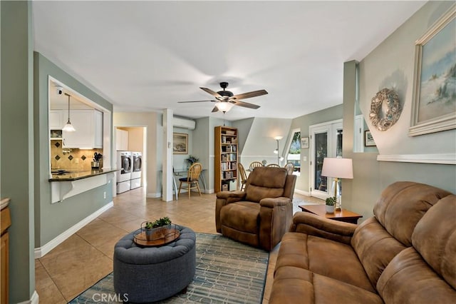 living room featuring french doors, ceiling fan, an AC wall unit, independent washer and dryer, and light tile patterned flooring