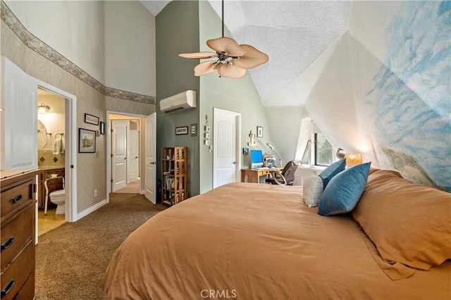 carpeted bedroom with lofted ceiling, ensuite bath, ceiling fan, a textured ceiling, and a wall unit AC