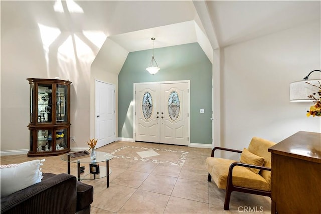 tiled foyer entrance featuring french doors and vaulted ceiling