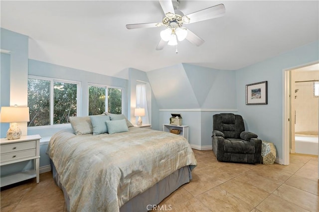 tiled bedroom featuring ensuite bathroom and ceiling fan