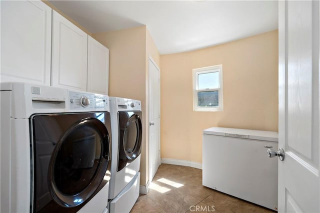 laundry room with washer and dryer, light tile patterned floors, and cabinets