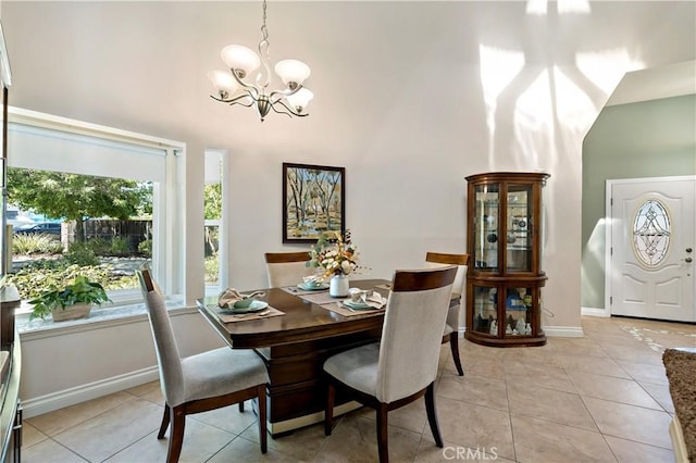 dining space with a chandelier, light tile patterned floors, and a towering ceiling