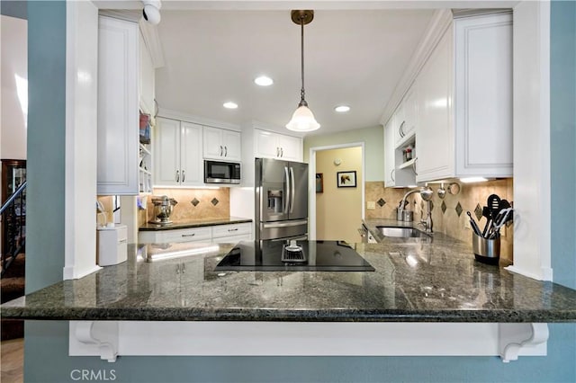 kitchen featuring sink, hanging light fixtures, kitchen peninsula, white cabinets, and appliances with stainless steel finishes